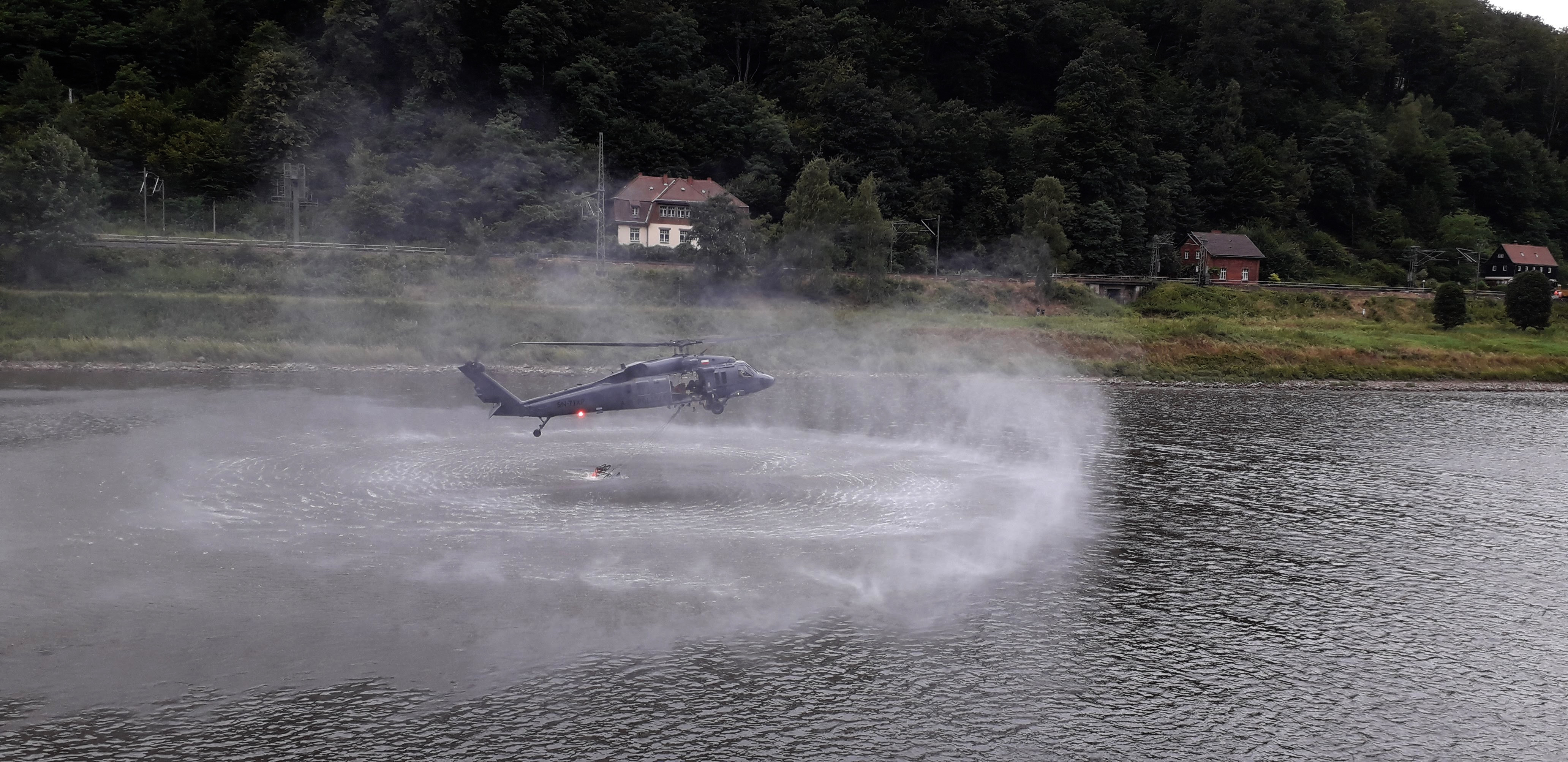 Polský policejní vrtulník nabírá hasební vodu z Labe. Foto: Tomáš Salov