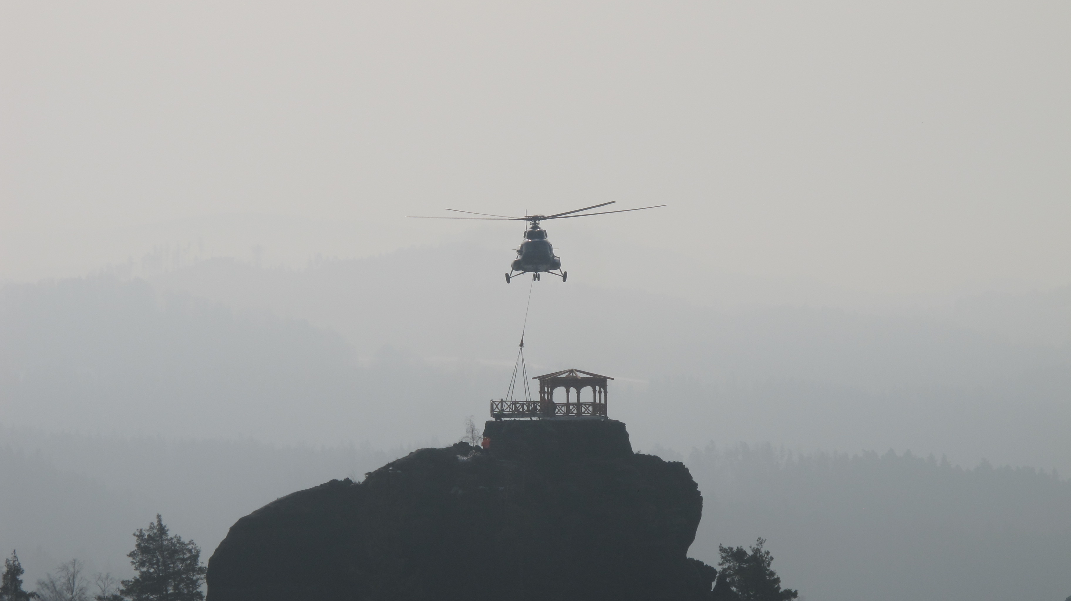 Vrtulník usazuje vyhlídkovou plošinu před altánem na Mariině vyhlídce