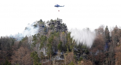 Vrtulník hasí lesní požár pomocí vodního vaku. Foto: Václav Sojka